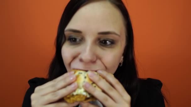 Geistloses Essen, Fast Food, ungesunde Ernährung, Überernährung, Selbstkontrolle, Hunger, Ernährungskonzept. junge Frau isst gierig großen leckeren Hamburger — Stockvideo