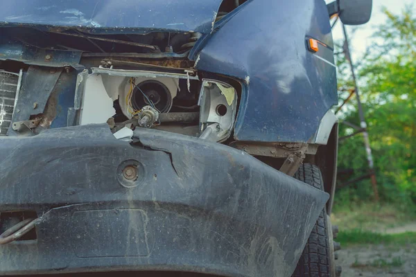 Unohdettu ruosteinen auto tiellä rikkinäisellä ajovalolla, hylätty ruosteinen auto romuttamolla — kuvapankkivalokuva