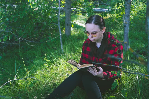 Woman reading a book in a green summer forest. — Stock Photo, Image