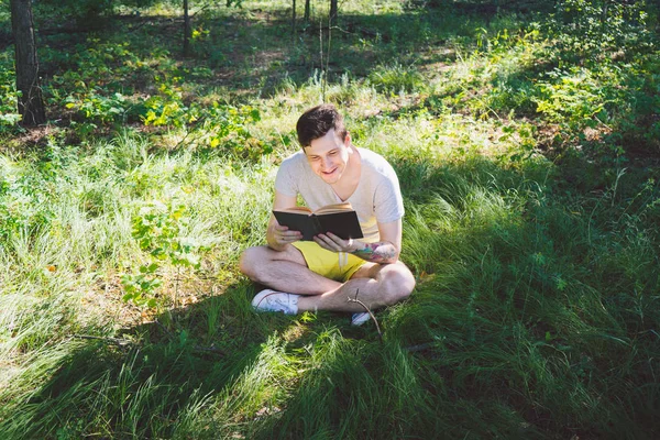 Jeune homme beau livre de lecture dans l'espace ouvert — Photo