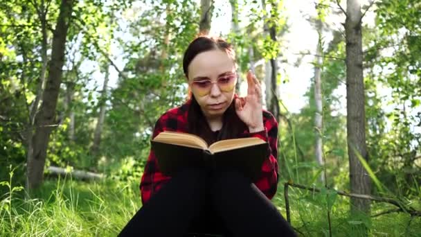 Donna che legge un libro in una foresta verde estiva . — Video Stock