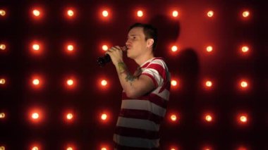 Dövmesi olan bir adam serinletici bir içki içer. Genç beyaz erkek şişeden bir içki içiyor