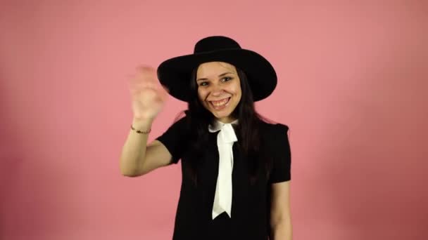 Feliz mujer de negocios agitando su mano sobre fondo rosa. Señora mirando a la cámara en el estudio. El concepto de bienvenida . — Vídeos de Stock