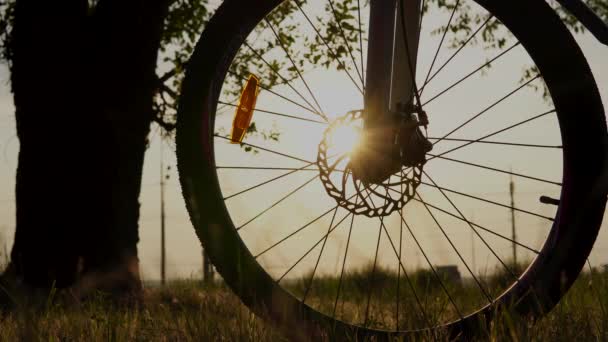 일몰 때 가까이 서 볼 수있는 자전거의 아름다운 광경, 포도 빛깔의 푸른 하늘에 내리쬐는 태양, 태양을 향한 태양을 향한 자전거의 실루엣. — 비디오