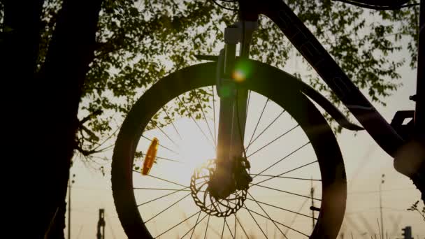 Belle scène de gros plan de vélo au coucher du soleil, soleil sur le ciel bleu avec des couleurs vintage, silhouette de vélo vers l'avant au soleil. — Video