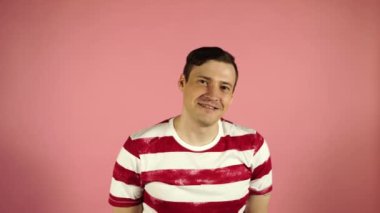 Adam gülümseyen ve pembe arka plan üzerinde ayakta şaşkın
