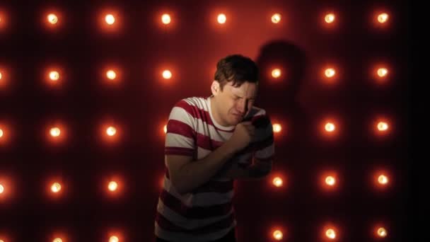 Mann hustet auf rotem Hintergrund stehend. sich unwohl oder krank fühlen — Stockvideo