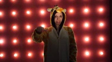 Hiç hoşuma gitmedi. Kadın kırmızı bir arka plan üzerinde başparmak ile gibi sevmediğim yapıyor. Parlak çocuklu bir kadın kanguru şeklinde pijama. çocuk animatör kostüm sunumu.