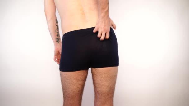 Man i shorts skrapa hans kliande röv — Stockvideo