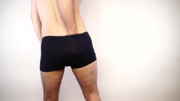 Человек в шортах чешет свою зудящую задницу — стоковое видео