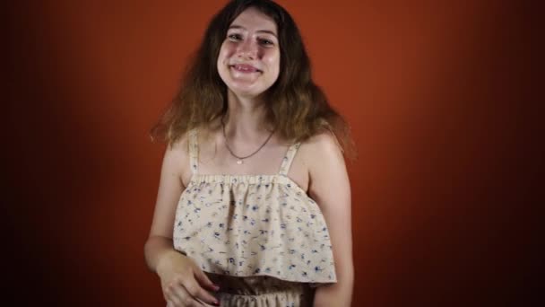 Sonriente morena mujer mostrando ok signo y mirando a la cámara sobre fondo naranja — Vídeos de Stock