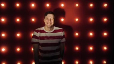 Adam gülümseyen ve kırmızı arka plan üzerinde ayakta şaşkın