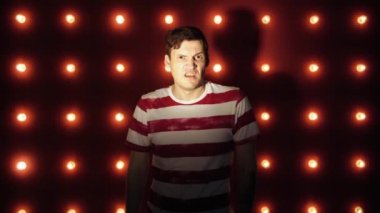 Kırmızı arka plan üzerinde çizgili tişörtlü bir adam. Kamera ya da kamera hayır diyor