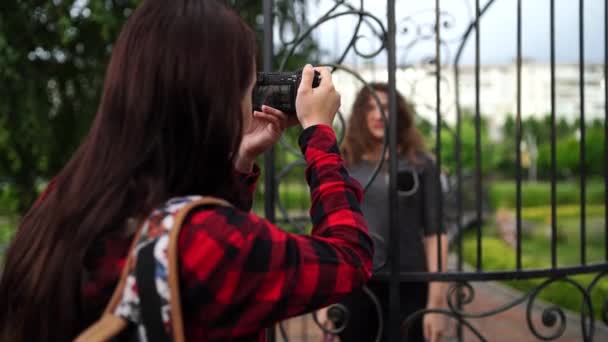 Park'ta bir kadın fotoğrafçı için poz kadın — Stok video