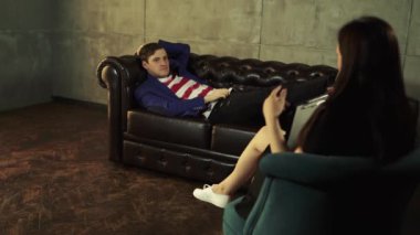 Bir psikoloğun resepsiyonundaki adam sorunları hakkında konuşuyor. Psikolog danışman resepsiyonundaki mutsuz erkek. Danışman psikolog resepsiyonu. Konsept: Bir Kadın psikolog