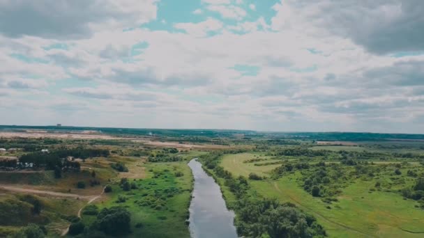 De rivier gaat in de verte omringd door groene bomen op een heldere dag — Stockvideo