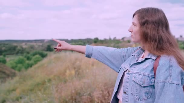 Jeune femme regardant au loin dans le contexte de la nature. Mignon sourire femelle debout à l'extérieur . — Video