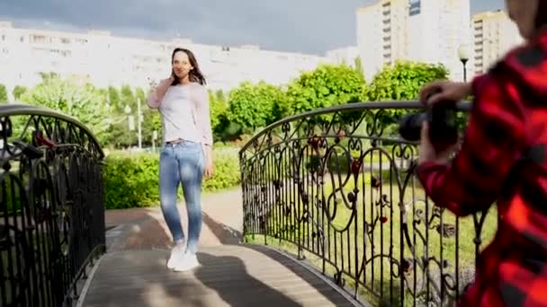 Photographe fille, photographiant une femme à l'extérieur, dans le parc par une journée nuageuse — Video