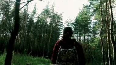 Parkta yürüyen isimsiz bir kadın. Süslü sırt çantalı genç bir bayanın arka görüntüsü. Sessiz sonbahar parkında yol boyunca yürüyor.