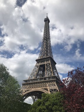 Paris 'teki Eyfel Kulesi, ağaçlara karşı. Aşağıdan görünüm