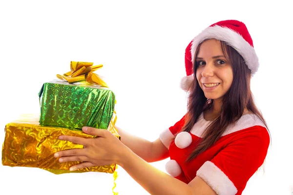 Lächelnde junge Frau im Weihnachtsmannanzug hält Geschenke auf weißem Hintergrund. Frohe Weihnachten und ein gutes neues Jahr. — Stockfoto