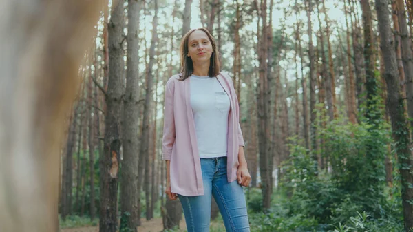 Jovem magro na floresta verde. Anel de madeira de árvore e mulher pensativa em pé na floresta olhando para cima — Fotografia de Stock