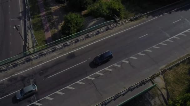 Samochody poruszają się po autostradzie otoczony zielonymi drzewami latem. — Wideo stockowe