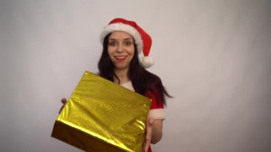 Noel Baba kostümü içinde gülümseyen genç bir kadın beyaz bir arka planda hediyeler tutuyor. Mutlu Noeller ve mutlu yıllar..