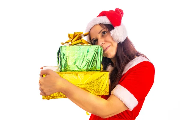 Noel Baba kostümü giymiş genç bir kadın. Elinde hediyeler, gülümseyen esmer bir kadın. Yeni yıl kostümü ve şapka sarılı hediyeler ve beyaz arka planda izole edilmiş kameraya bakmak — Stok fotoğraf