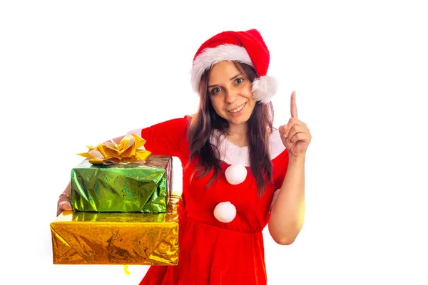 Jeune femme en costume Santa Clause tenant des cadeaux enveloppés Bonne brune souriante. Costume et chapeau du Nouvel An tenant des cadeaux enveloppés et regardant une caméra isolée sur fond blanc — Photo