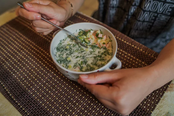 冷たいスープ名- okroshka,ロシアとウクライナの料理の国民料理.新鮮なキュウリ、大根、ジャガイモとボウルにヨーグルトとソーセージと冷たいスープ. — ストック写真