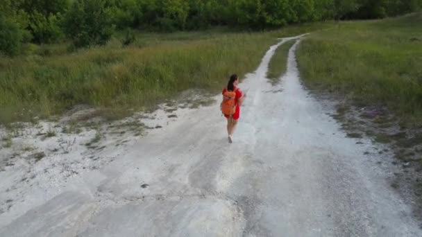 Cestující žena s mapou v přírodě. Žena s batohem kráčející úzkou klikatou stezkou mezi zelenými keři a stromy. Nenucená žena s batohem. Cestovatel cestuje sám — Stock video