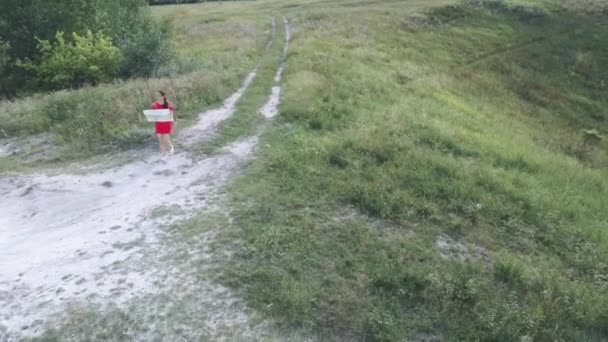 Viaggiare donna con mappa nella natura. Donna con zaino a piedi in stretto sentiero tortuoso che attraversa cespugli e alberi verdi. Donna casual che trasporta zaino. Viaggiatori che viaggiano da soli — Video Stock