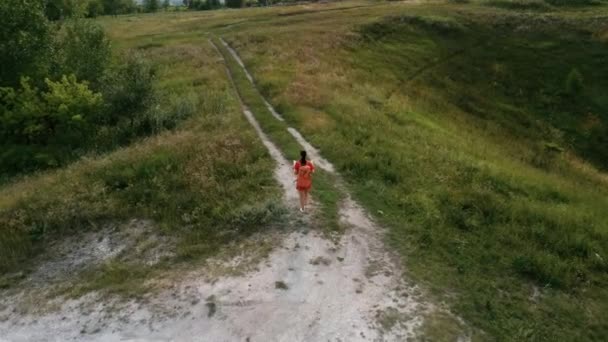 Mulher viajando com mapa na natureza. Mulher com mochila andando em caminho sinuoso estreito passando por arbustos verdes e árvores. Mulher casual carregando mochila. Viajante viajando sozinho — Vídeo de Stock