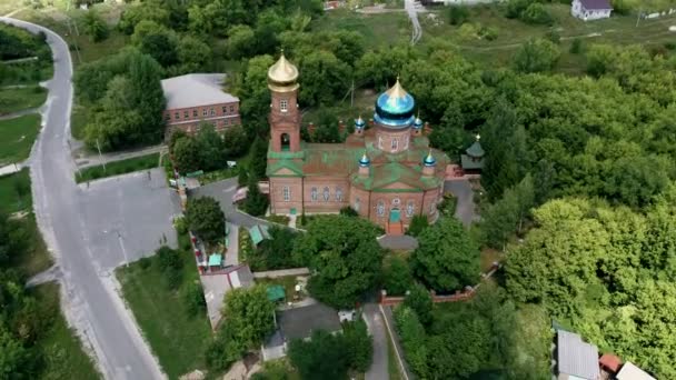 Röd tegelkristen kyrka med gyllene kupoler. Kristet tempel i Ryssland. Den kristna kyrkans kyrka är ett monument över rysk andlig och religiös arkitektonisk tradition och ortodoxi. — Stockvideo