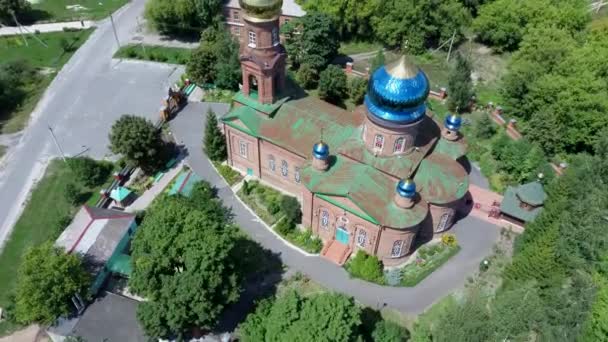 Rode bakstenen christelijke kerk met gouden koepels. Christelijke tempel in Rusland. De kerk van de christelijke kerk is een monument van de Russische geestelijke en religieuze architectonische traditie en orthodoxie. — Stockvideo