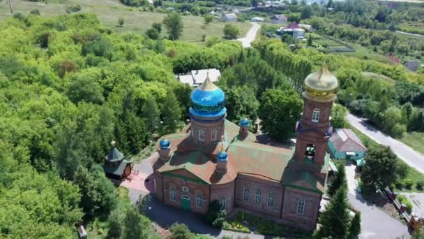 Rode bakstenen christelijke kerk met gouden koepels. Christelijke tempel in Rusland. De kerk van de christelijke kerk is een monument van de Russische geestelijke en religieuze architectonische traditie en orthodoxie. — Stockvideo