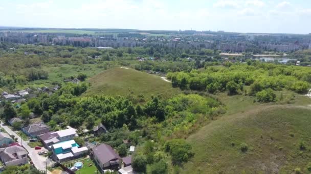 Chmurne niebo nad odległym miastem. Białe chmury unoszące się na błękitnym niebie nad budynkami odległego miasta i pagórkowatych obrzeży — Wideo stockowe