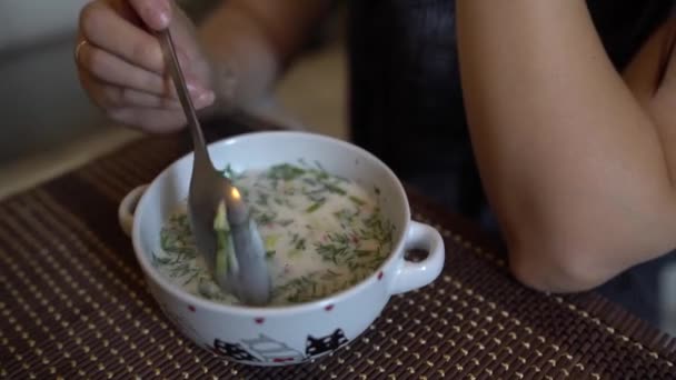 Nome da sopa fria - okroshka, o prato nacional da cozinha da Rússia e Ucrânia. Sopa fria com pepinos frescos, rabanetes, batata e salsicha com iogurte em tigela. — Vídeo de Stock