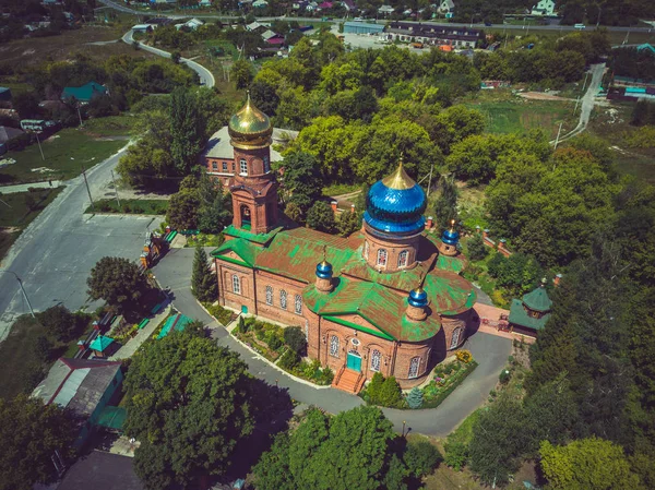 Röd tegelkristen kyrka med gyllene kupoler. Kristet tempel i Ryssland. Den kristna kyrkans kyrka är ett monument över rysk andlig och religiös arkitektonisk tradition och ortodoxi. — Stockfoto