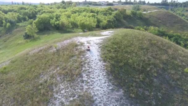 Vackert vår- och sommarlandskap. Bergslandvägen bland gröna kullar. Gröna kullar, höga berg. Vårblommande gräs. Sommar naturlig bakgrund. — Stockvideo