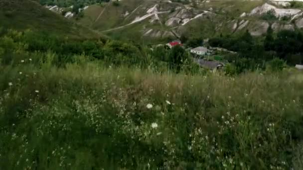 Vackert vår- och sommarlandskap. Bergslandvägen bland gröna kullar. Gröna kullar, höga berg. Vårblommande gräs. Sommar naturlig bakgrund. — Stockvideo