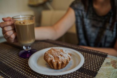 Fast food Cafe 'nin masasındaki tabakta lezzetli kekle sıcak kahve..