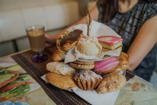 Фотография продуктов питания. Горячий капучино с разными домашними пирогами в корзине на столе в кафе быстрого питания. — стоковое фото