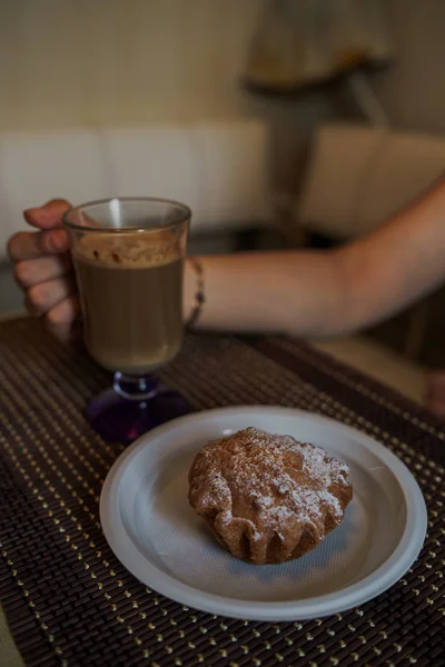Горячий кофе с вкусным кексом в тарелке на столе в кафе быстрого питания. — стоковое фото