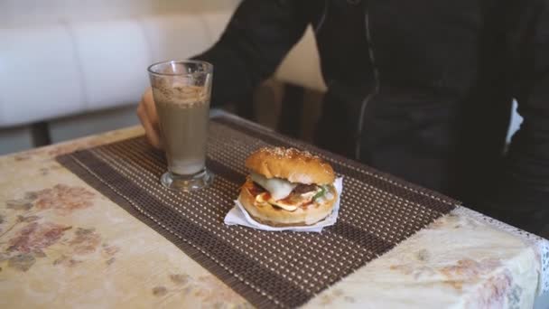 食品写真 ホットカプチーノとハンバーガーのテーブルでファーストフードカフェ — ストック動画