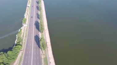 Köprüdeki arabalarla köprüden uzaktan kumandalı insansız hava aracı görüntüleri. Nehir üzerindeki beton köprünün hava görüntüsü, şehir köprüsünde araba trafiği, ulaşım konsepti.