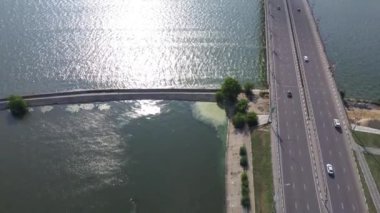 Köprüdeki arabalarla köprüden uzaktan kumandalı insansız hava aracı görüntüleri. Nehir üzerindeki beton köprünün hava görüntüsü, şehir köprüsünde araba trafiği, ulaşım konsepti.