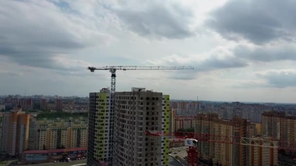 Gru e edificio in costruzione. Cantiere. Gru da costruzione e grattacieli in costruzione contro il cielo nuvoloso — Video Stock