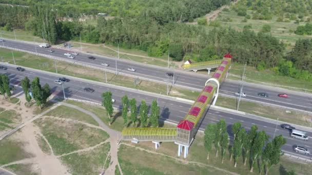 Modern bridge for pedestrians over the road. View from the top of the highway with suspended pedestrian crossings — Stock Video